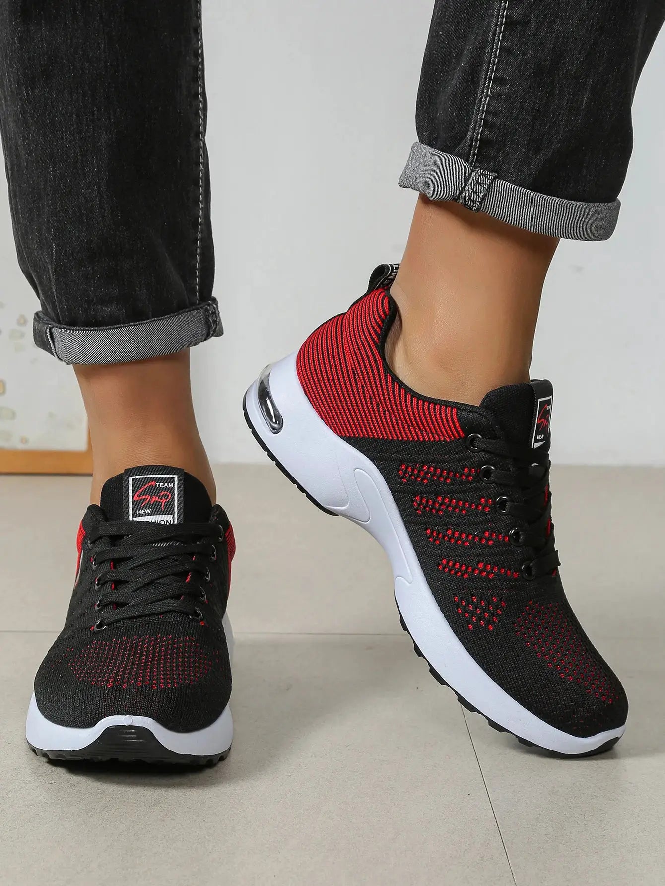 Men's running shoes by Simples Market, black/red knit upper with white cushioned sole, pair shown.