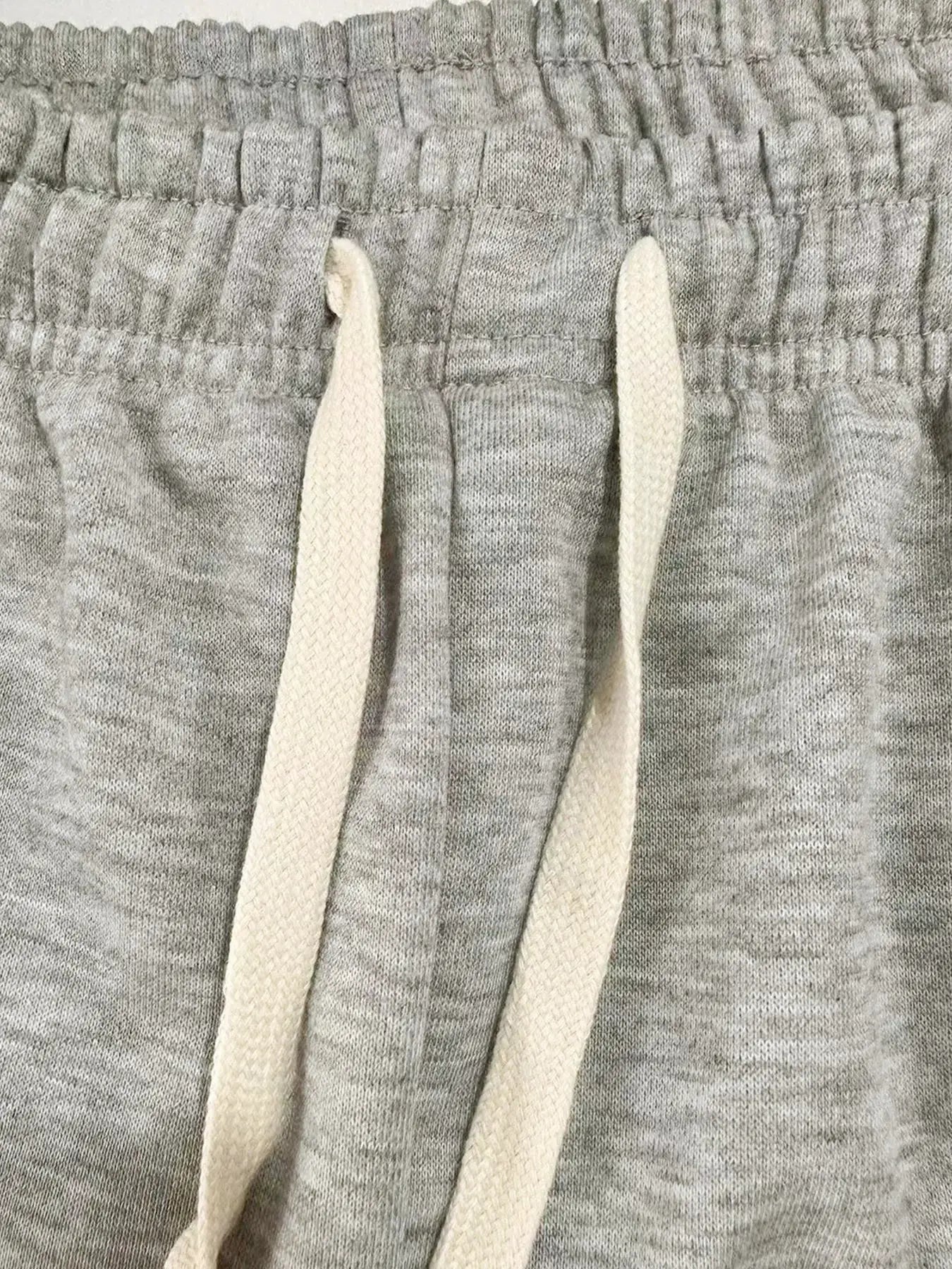 Men's grey jogger pants with elastic waistband and cream drawstrings, baggy breathable sweatpants