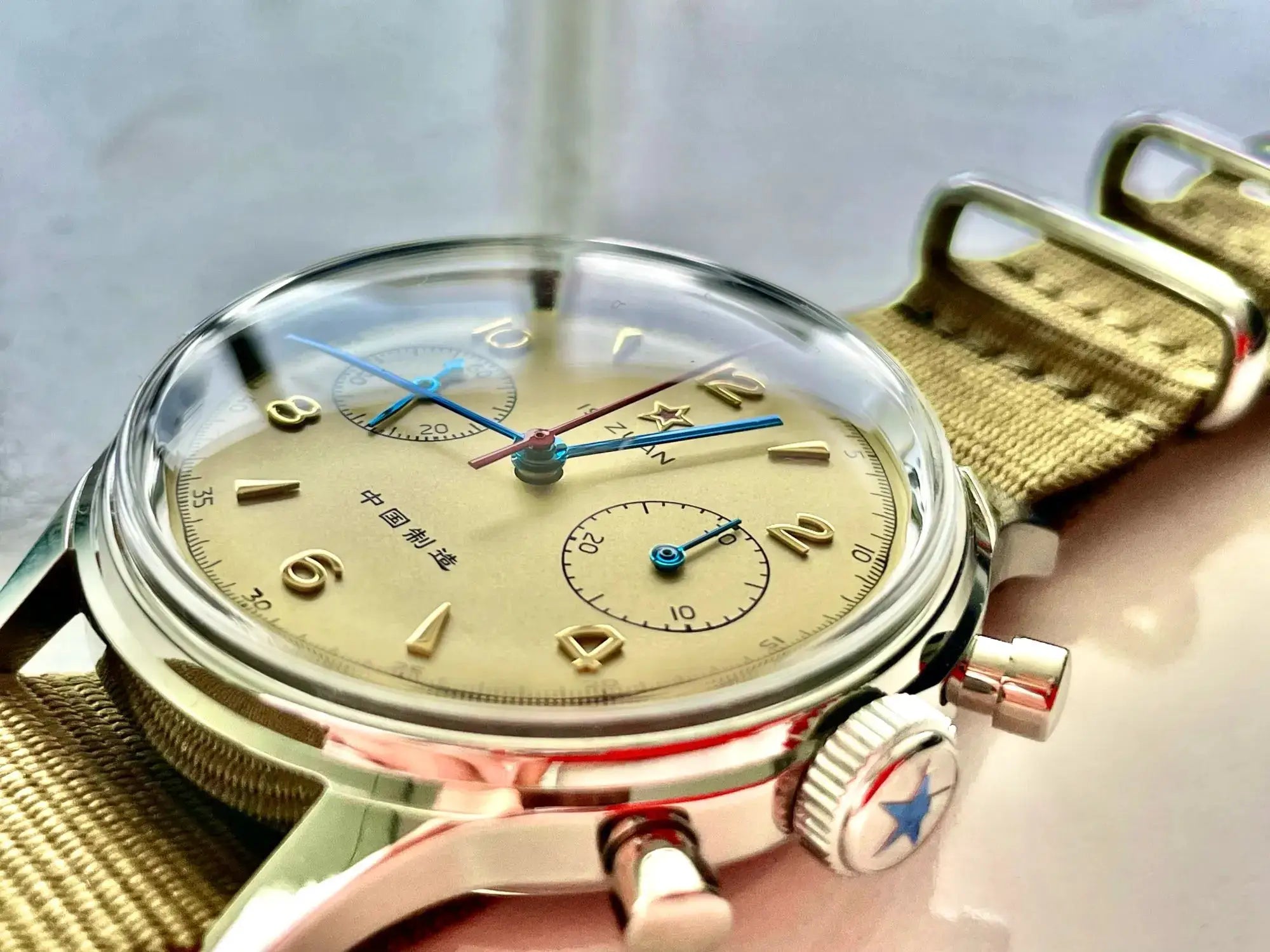 Red Star 38mm men's chronograph watch on a khaki canvas strap; beige dial with gold markers and blue hands.
