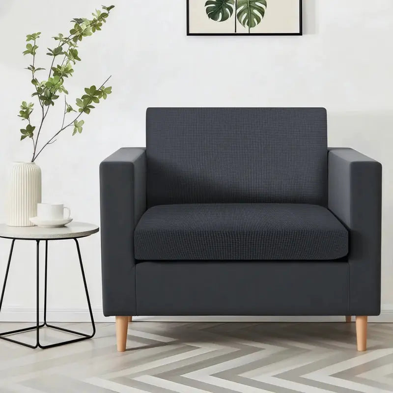 Armchair in dark gray textured fabric with wood legs.