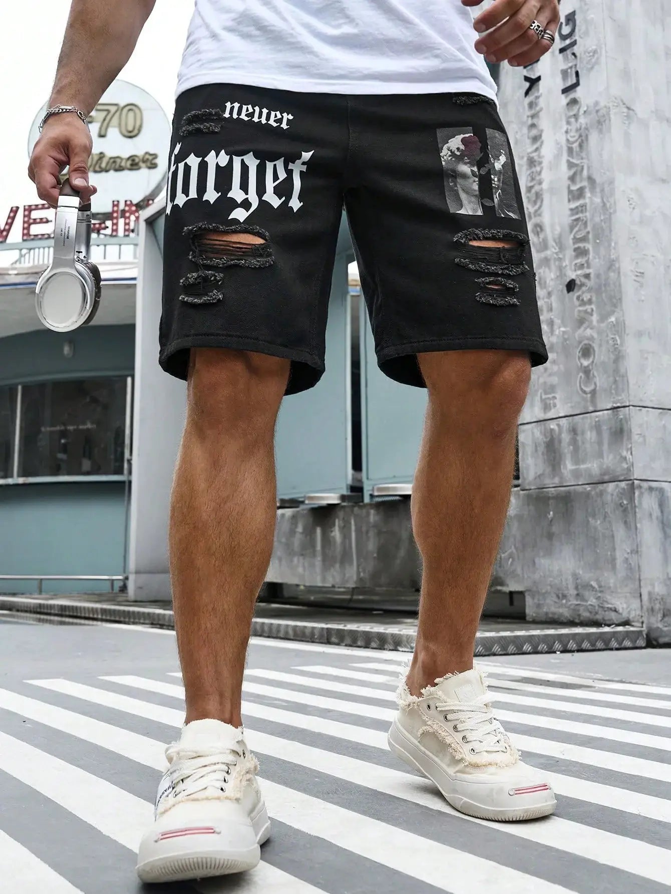 Men's black denim shorts with ripped knees and a graphic patch, baggy streetwear style