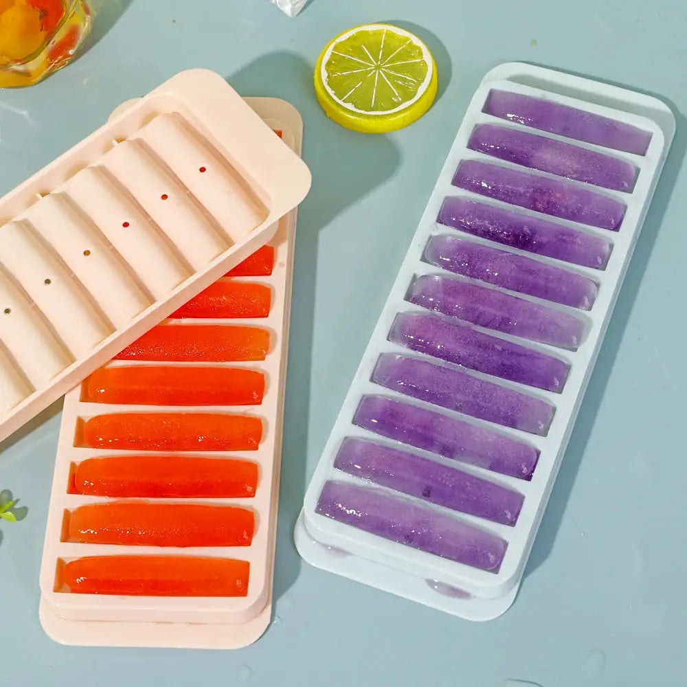 Long cylindrical ice cube molds by Simples Market; orange and purple ice bars in two trays.