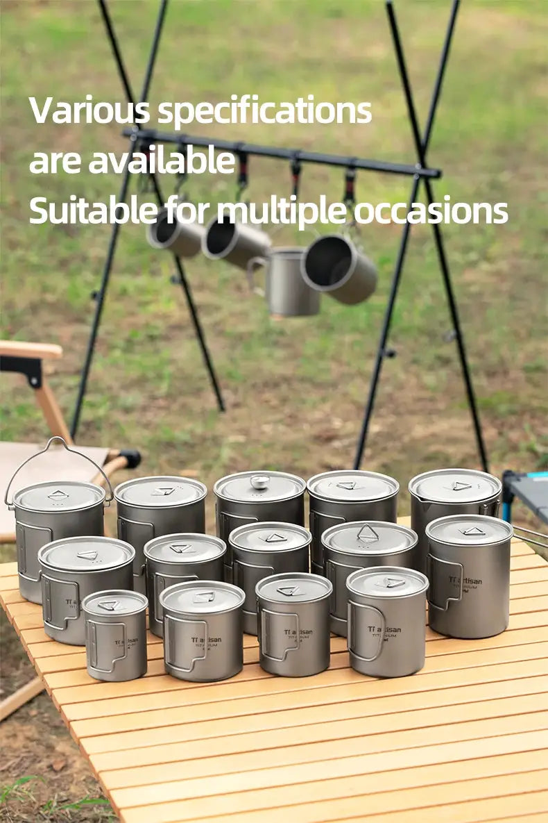 Tiartisan titanium camping mugs set with folding handles for tea or coffee, outdoors on a wooden table