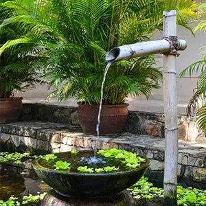 Solar fountain pump panel water kit for pond and garden; white pipe fountain over a lily pad pond
