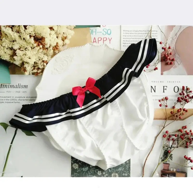 Navy blue milk-silk panties with white stripes, pink bow, and ruffled edges.
