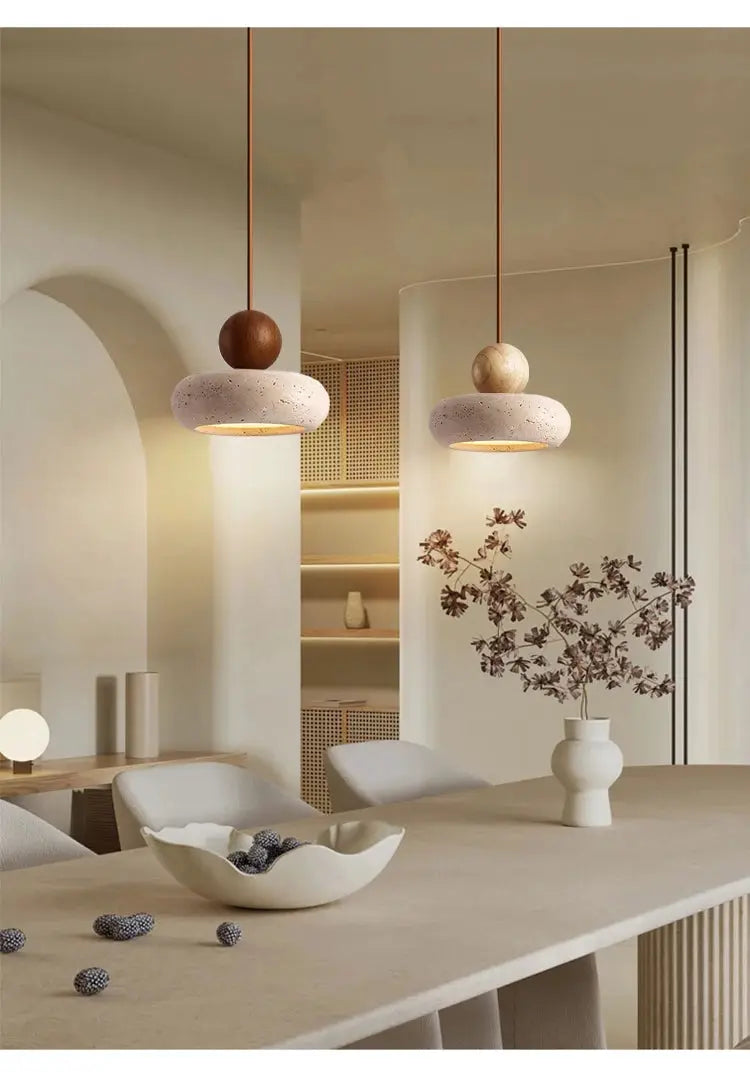 Vintage pendant lights with natural yellow agate stones, two warm stone discs over a wooden dining table.