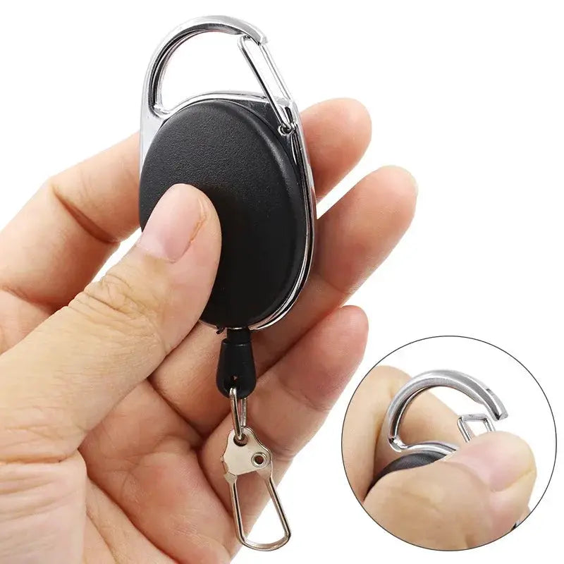 Retractable key chain badge reel with black oval housing, quick-release clip and metal carabiner