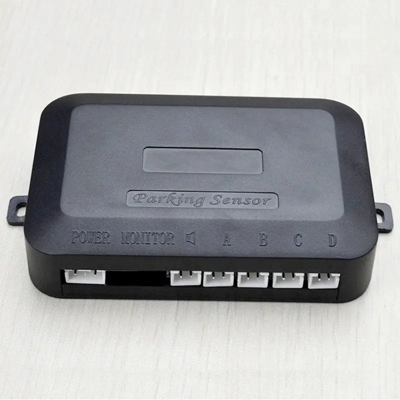 Parking sensor control unit, black plastic module with 4 sensor ports labeled A-D