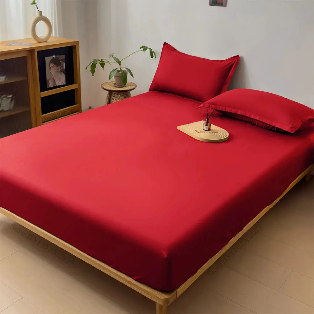 Simples Market waterproof fitted sheet for mattresses in red on a wooden bed with two red pillows