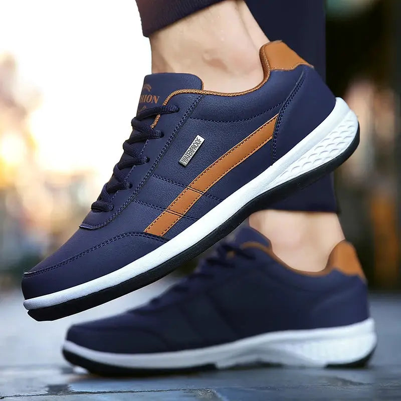 Leather men sneakers pair by Simples Market; navy blue with tan stripe, white sole, non-slip casual footwear.