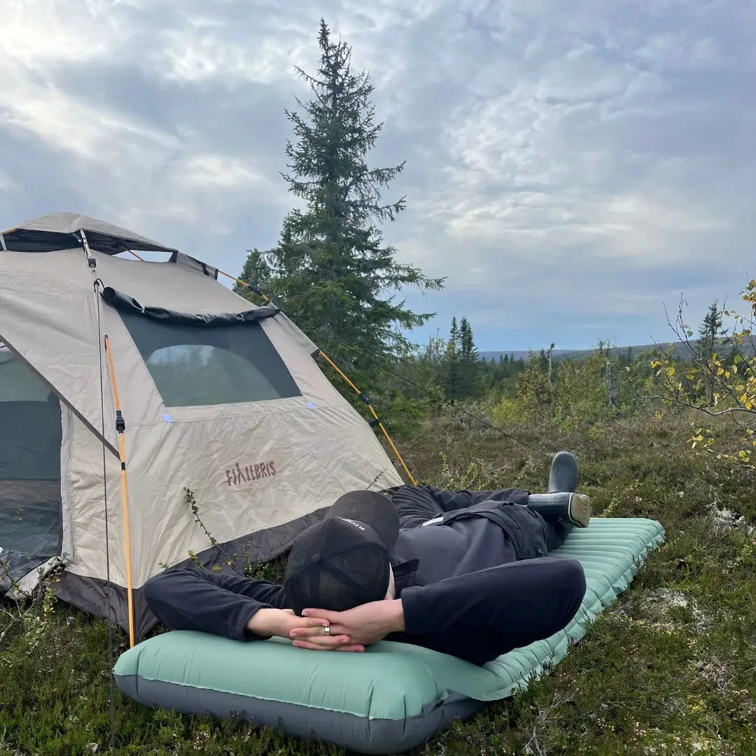 Extra thick 4in camping sleeping pad, green with gray sides, shown outdoors beside a tent