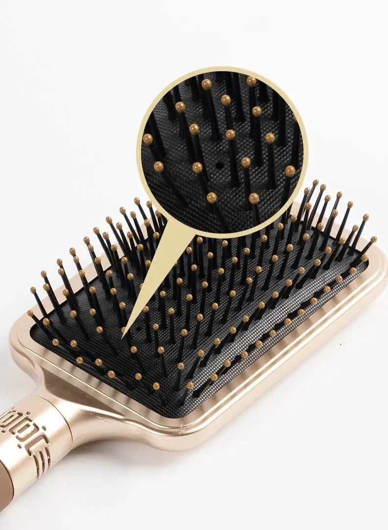 CALIYI hair massage air cushion brush by Simples Market, oval rose-gold handle with black cushion and gold-tipped bristles.