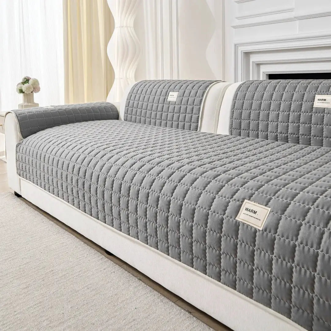 Sofa slipcover by Simples Market; gray quilted anti-slip protector on a living room sofa.