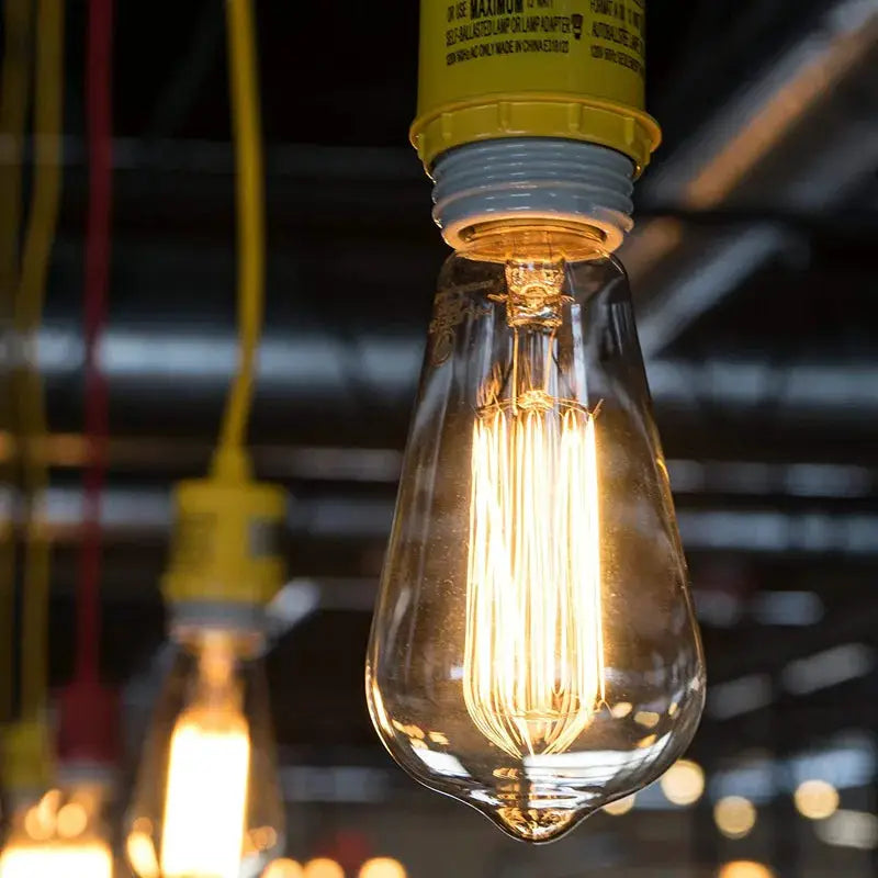Retro Edison bulbs by Simples Market; two clear glass filament bulbs with yellow E27 sockets, warm glow