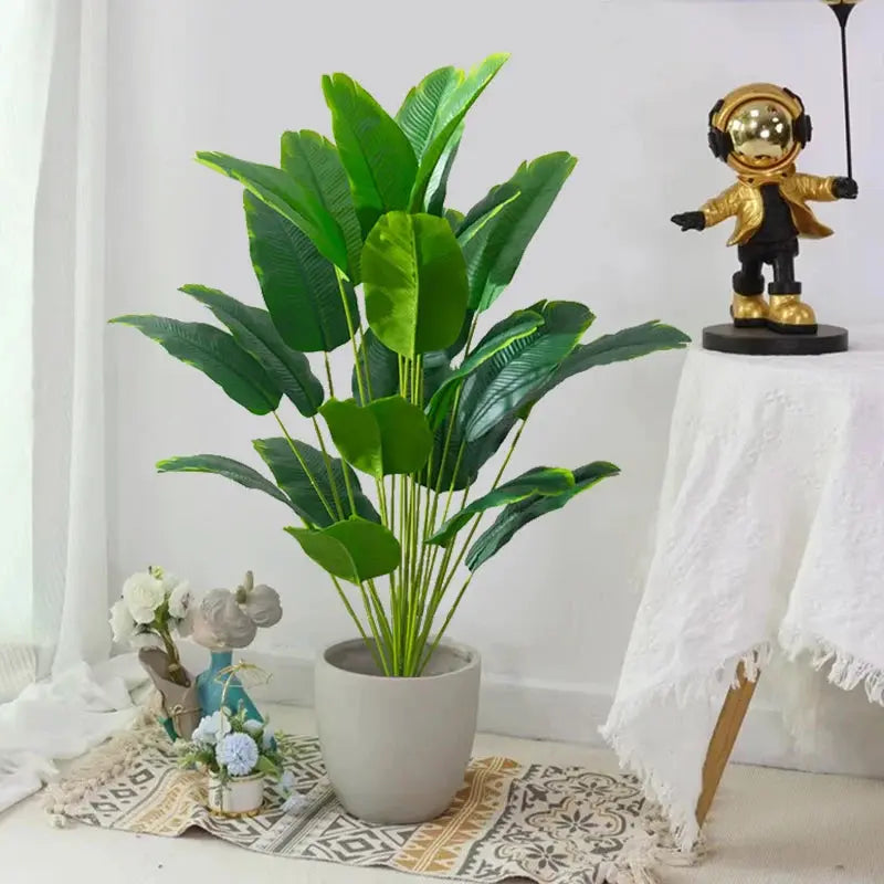 Artificial tropical palm plant in a white pot with large green plastic leaves