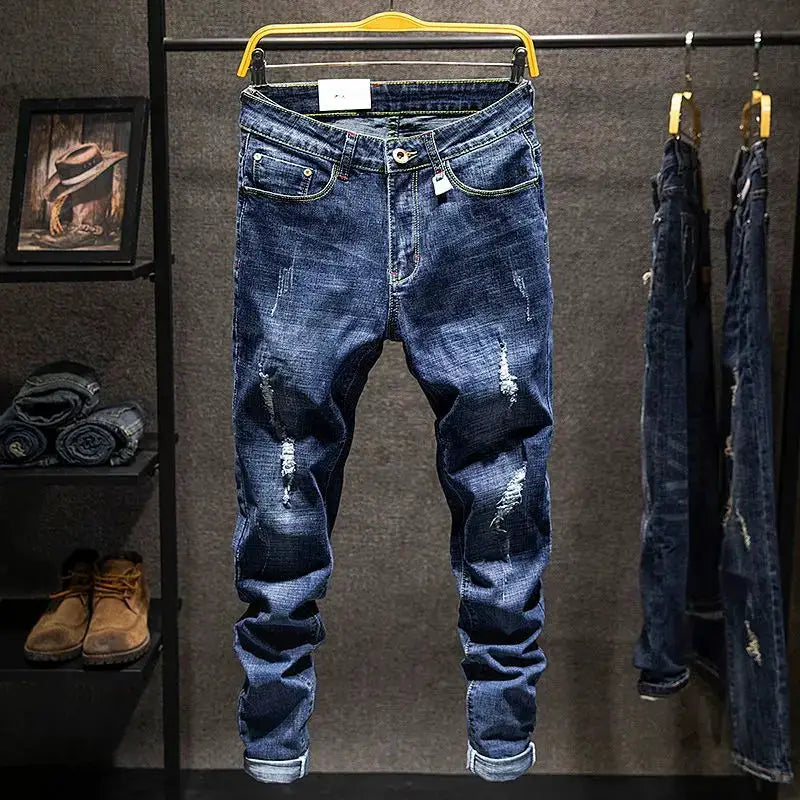 Men's distressed blue denim jeans with ripped details, straight fit on display