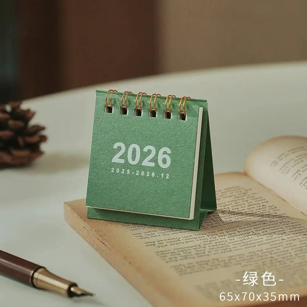 Green 2026 mini desk calendar with copper coil binding; compact desktop planner (65x70x35mm)