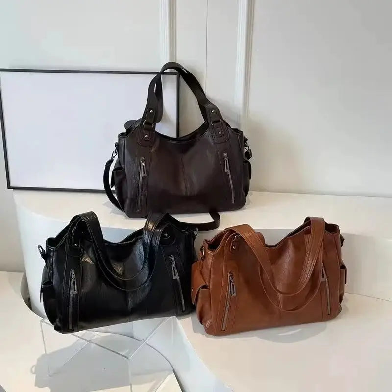 Shoulder bags set of 3 in black, brown and tan PU leather with zip pockets and top handles.