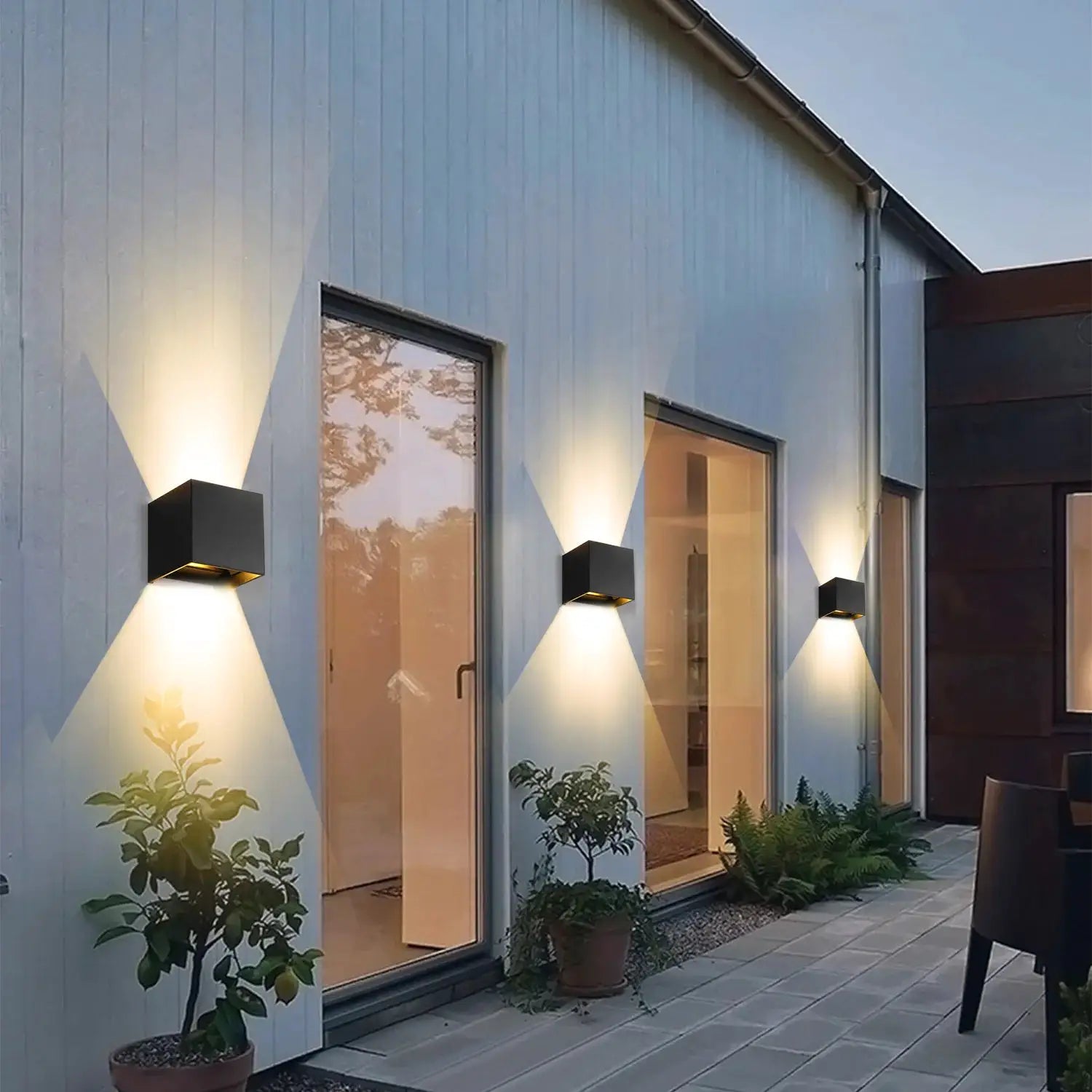 MARPOU LED wall lamps, set of 4 black cube outdoor wall lights casting upward and downward glow on a modern house wall