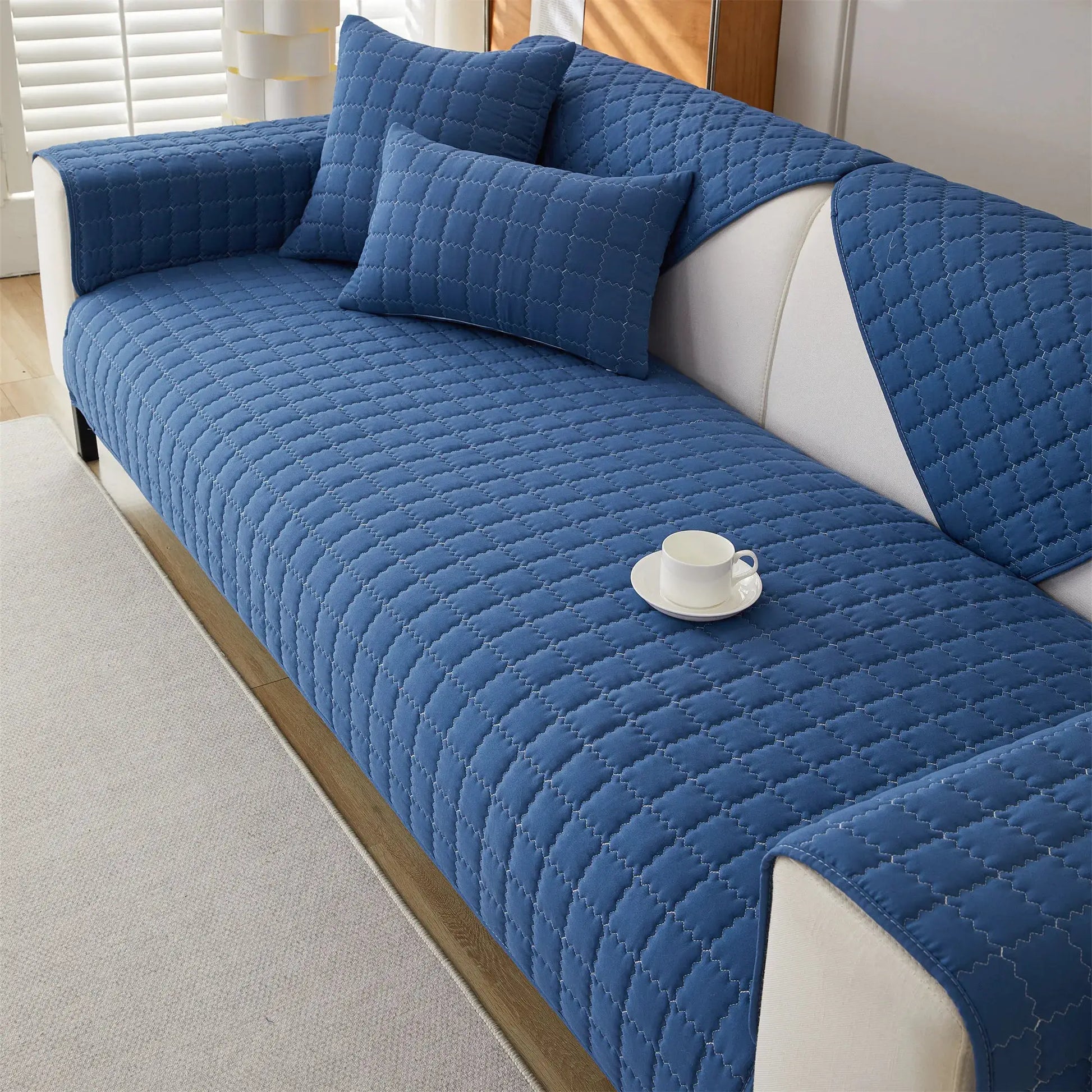 Quilted blue anti-slip sofa slipcover with two matching cushions.