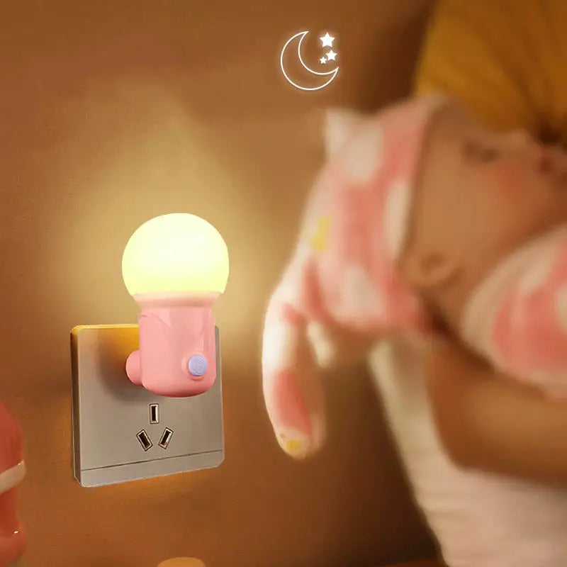 LED night light in pink plug-in design with warm yellow bulb mounted on a wall outlet