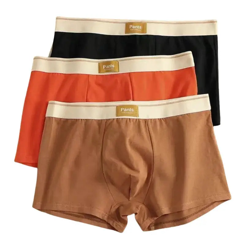 3-pack men's cotton boxer shorts in black, orange, and brown with beige elastic waistband.