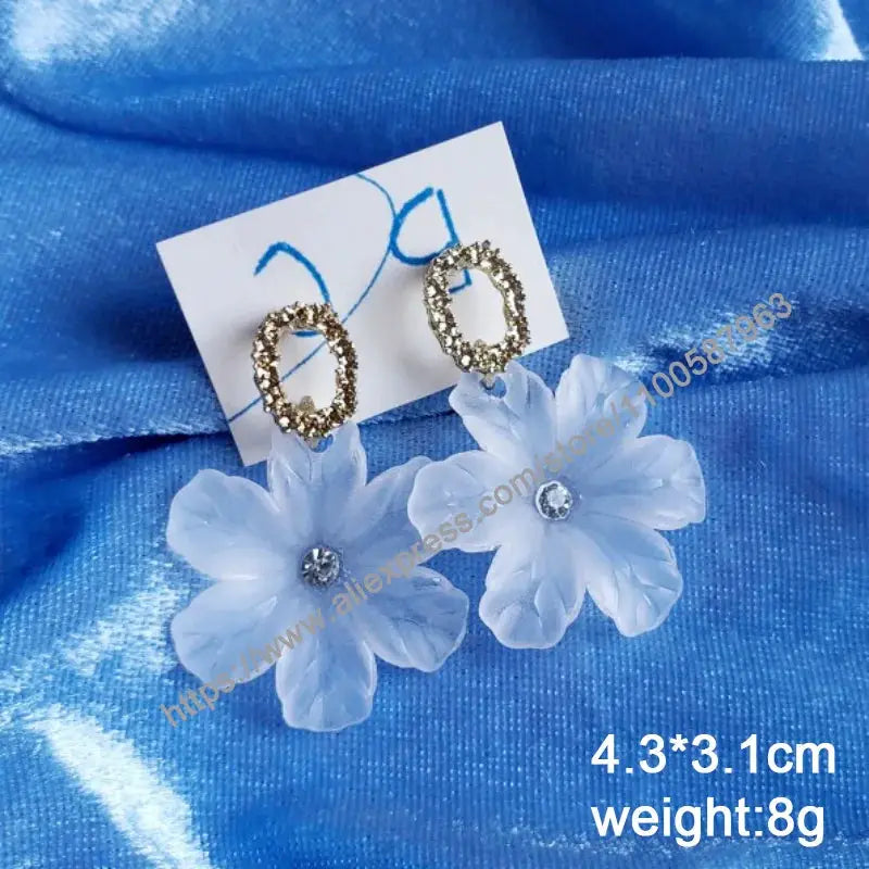 Simples Market pair of gold-tone oval drop earrings with blue blooming flower pendants and rhinestone centers