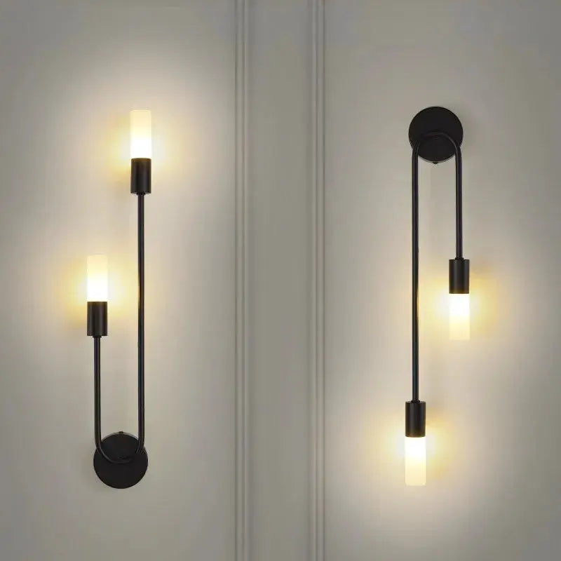Two LED wall lamps by Simples Market; golden-black minimalist sconces with frosted glass cylinders.