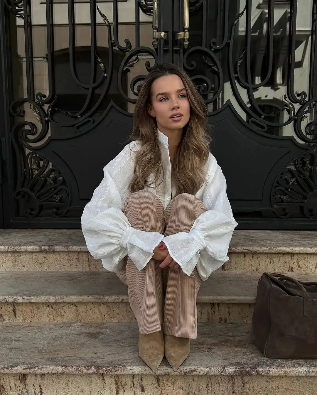Oversize white 100% cotton shirt for women with long sleeves and button-up, shown with beige corduroy pants.