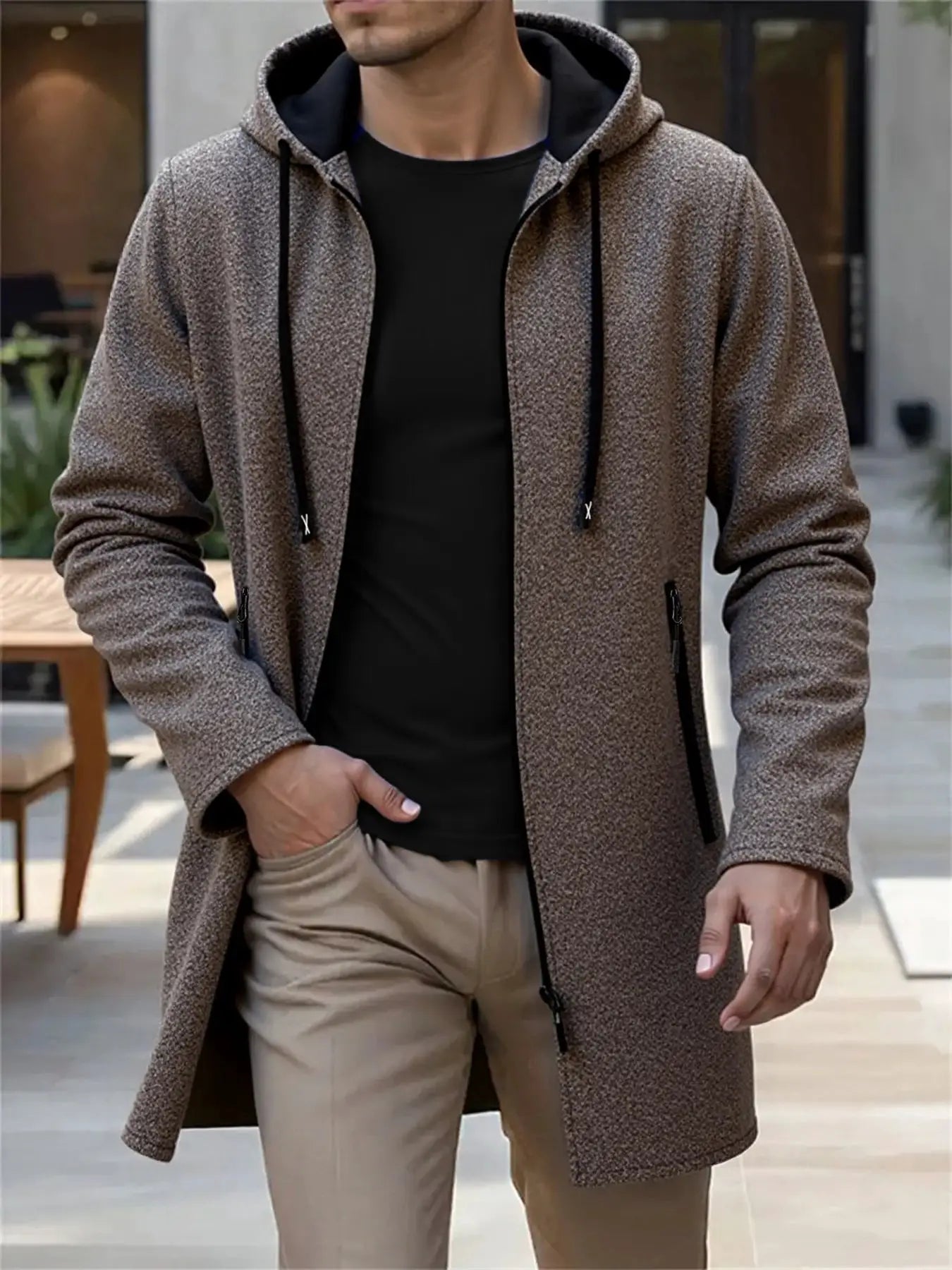 Men's hooded long jacket in brown speckled knit, front zipper, drawstring hood, and zippered pockets.