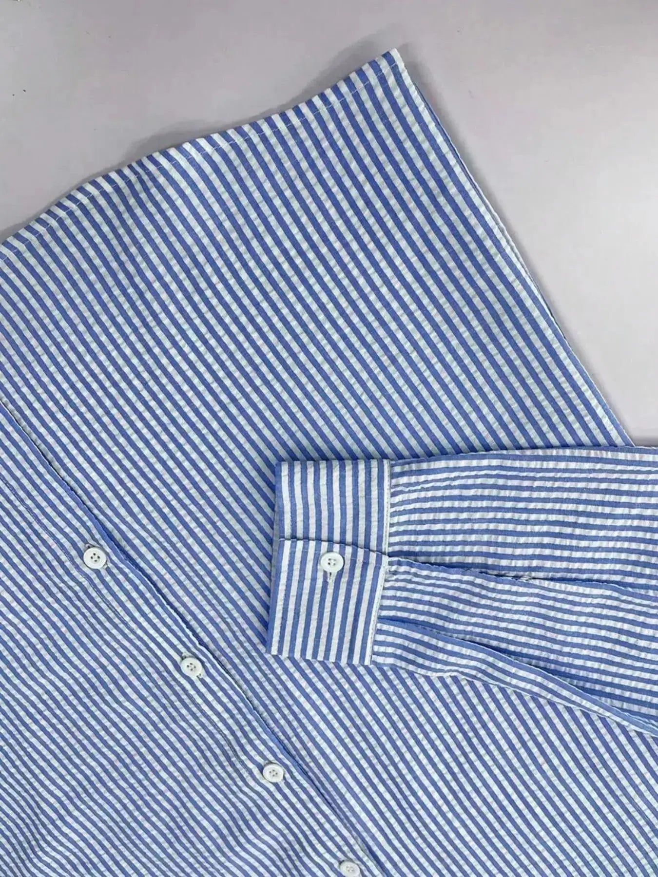 Men's blue and white striped long-sleeve shirt with button front and cuffs.