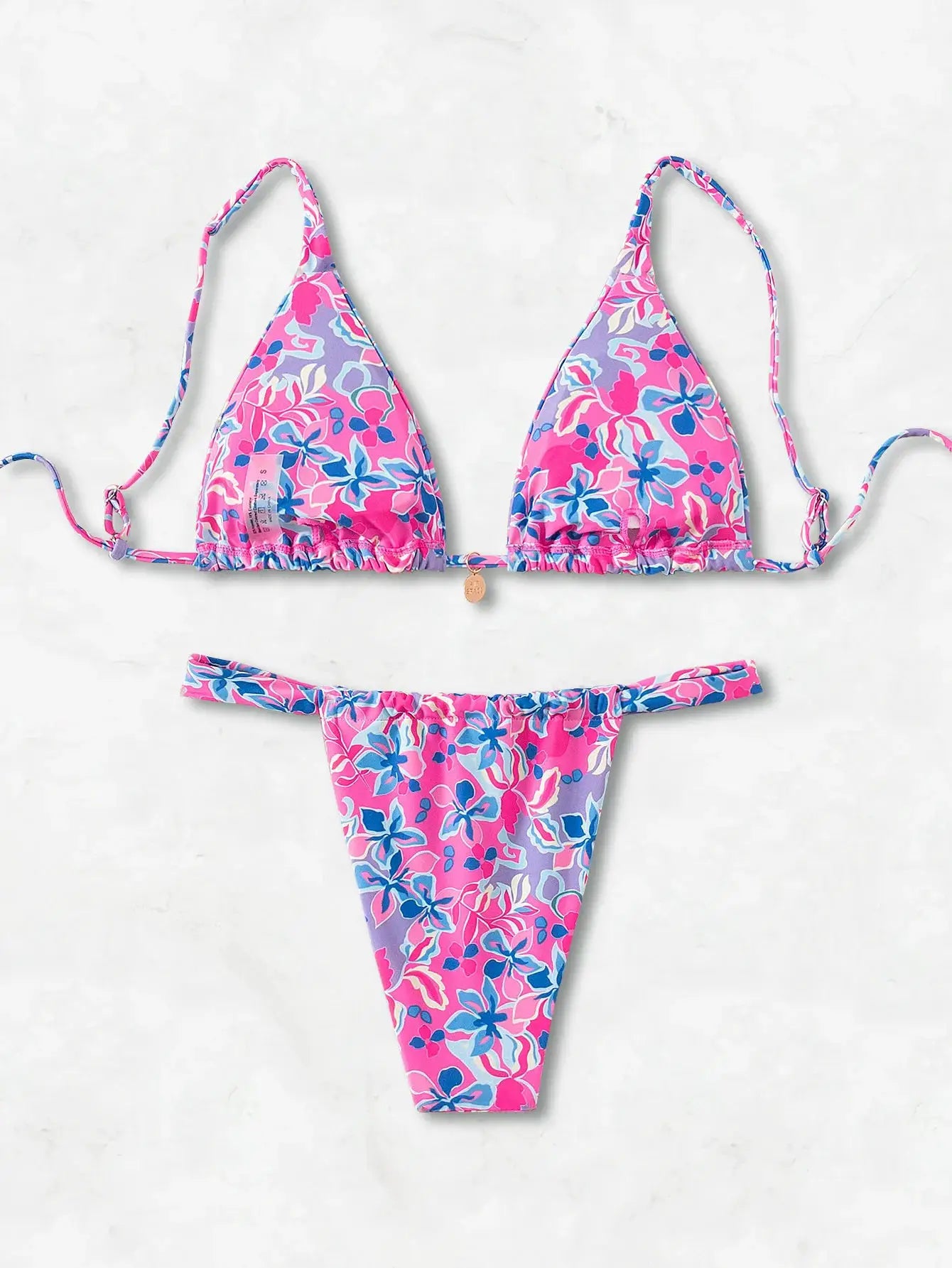 Simples Market floral print triangle bikini set with pink and purple hues; string-tie top and Brazilian bottoms.