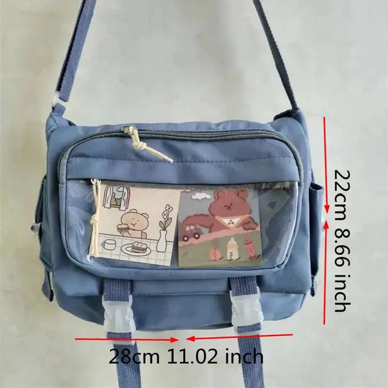 Simples Market blue canvas crossbody bag with large capacity, front clear-pocket display panels, adjustable shoulder strap.