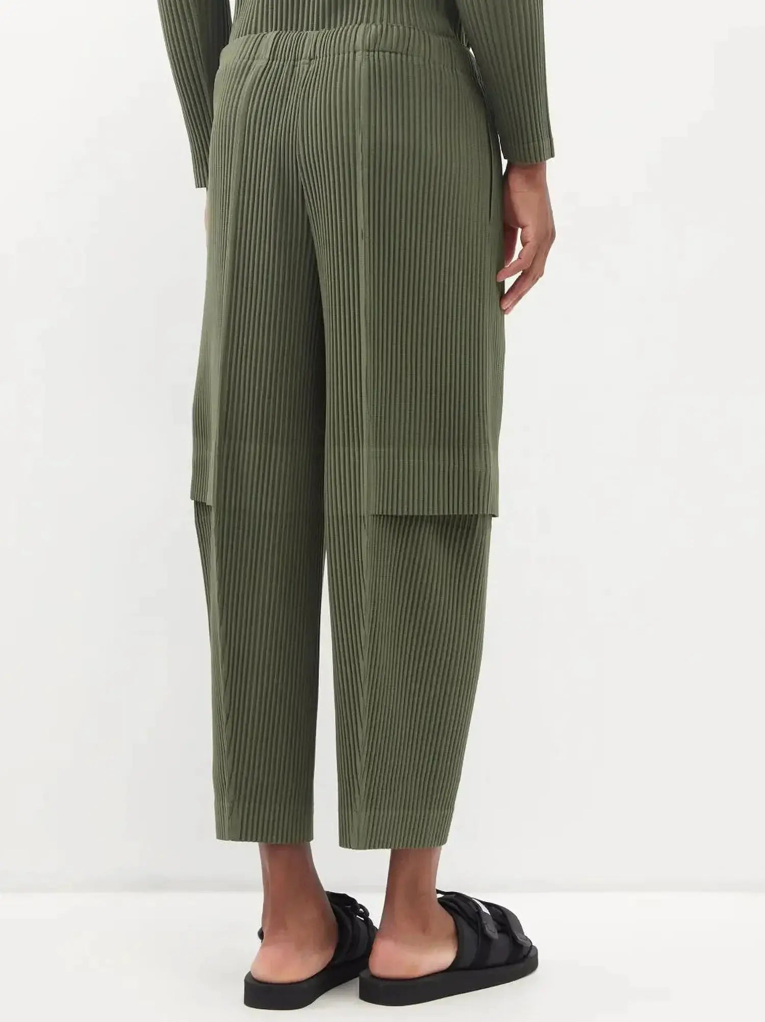 Miyake pleated cargo pants for men in olive green with vertical pleats and a loose baggy fit