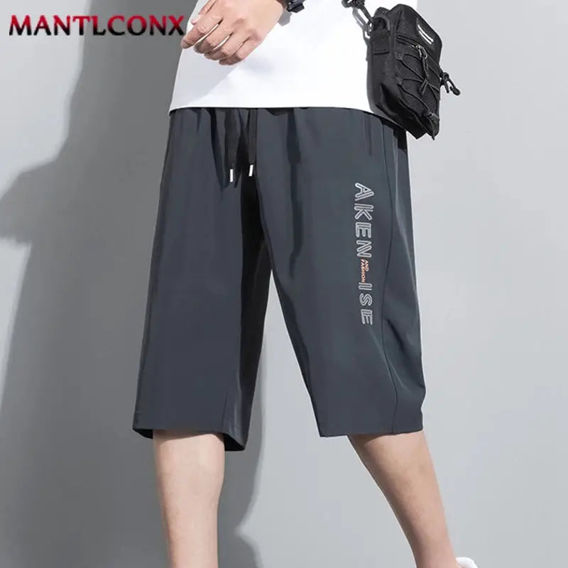 Men's black knee-length sport shorts with elastic waist and drawstring; breathable quick-dry fabric, MANTLCONX logo.