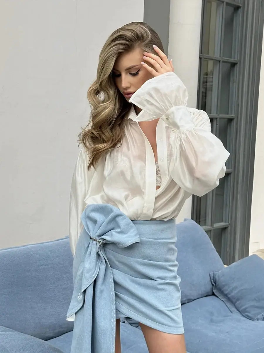 Bornladies white collared blouse with puff sleeves paired with light blue wrap skirt; two-piece outfit by Simples Market