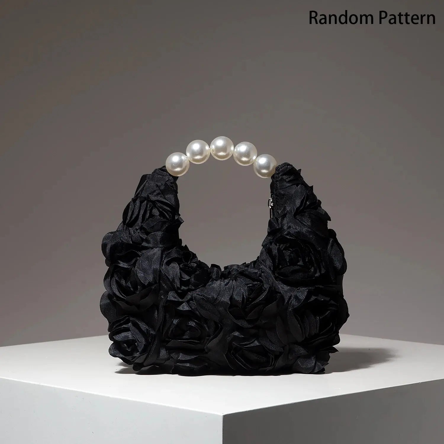 Pearl bracelet with white beads displayed on a black ruched fabric glove.