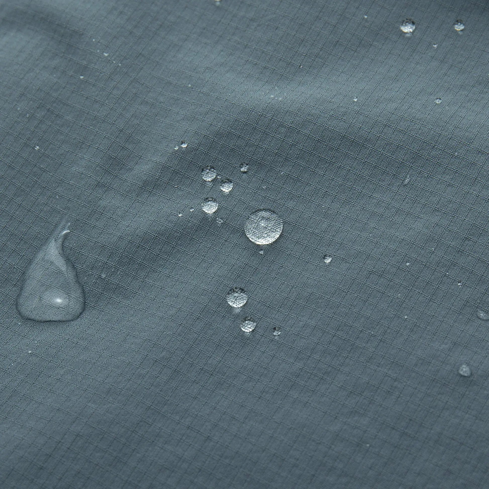 YKYWBIKE men's cycling windbreaker vest fabric close-up in blue-gray with water droplets.