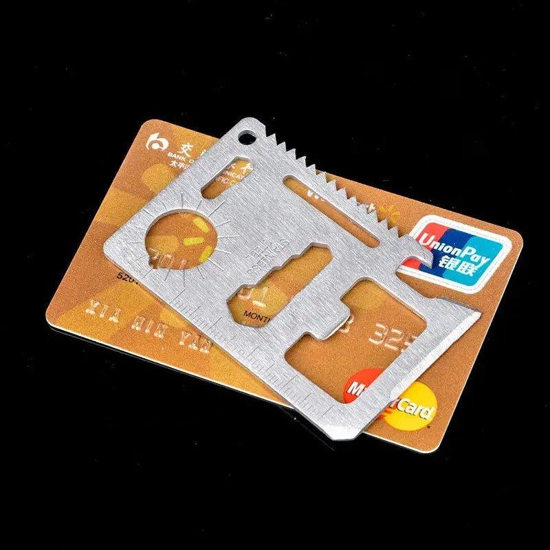 Wallet card knife EDC multitool by Simples Market on a gold bank card; stainless steel, compact