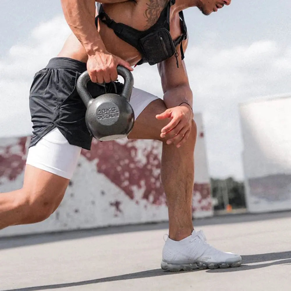 Men's 2-in-1 black fitness training shorts with quick-dry inner layer; white compression shorts visible.