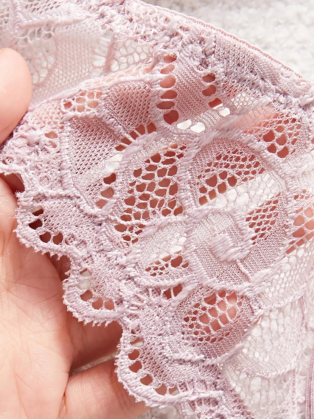 Soft pink lace bra close-up with patterned lace cups