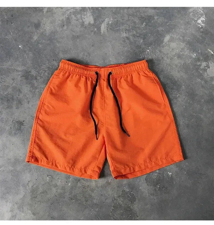 Orange men's swim shorts with black drawstrings, board shorts style