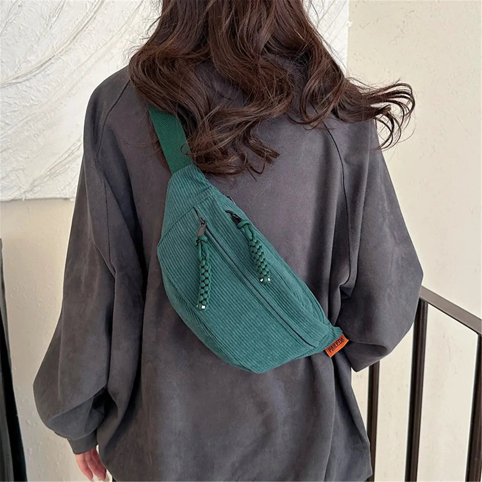 Corduroy belt bag teal by Simples Market worn crossbody with tassel zipper details