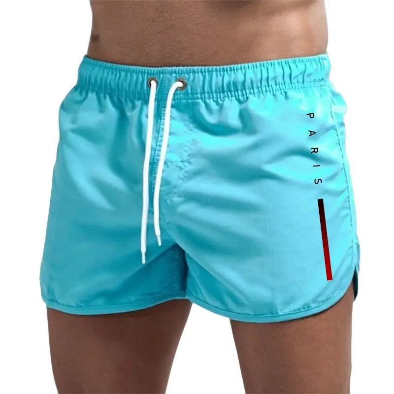 Men's turquoise board shorts with white drawstring, Paris graphic and red side stripe