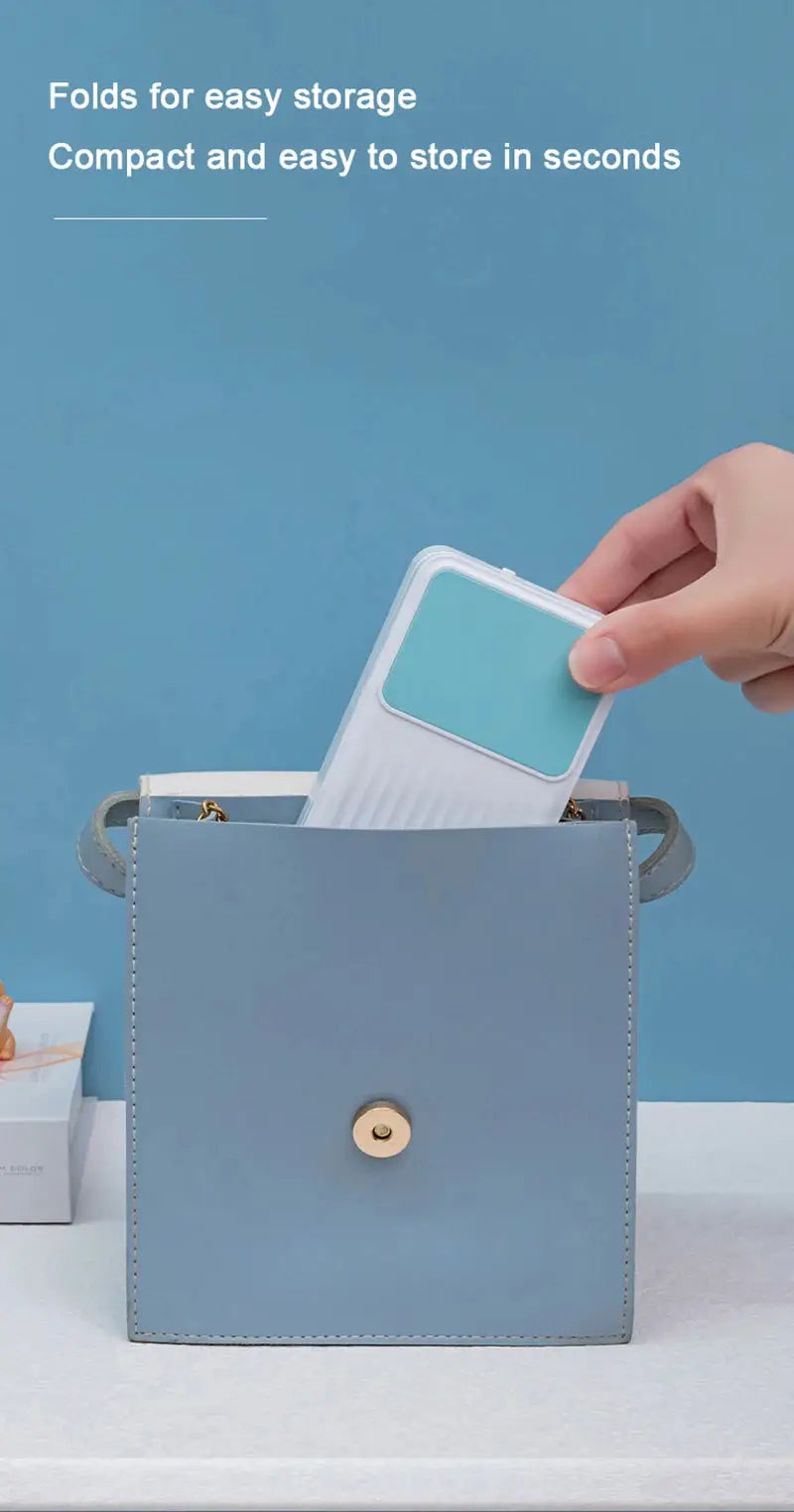 Folding LED desk lamp with white body and turquoise panel being placed into a blue storage bag