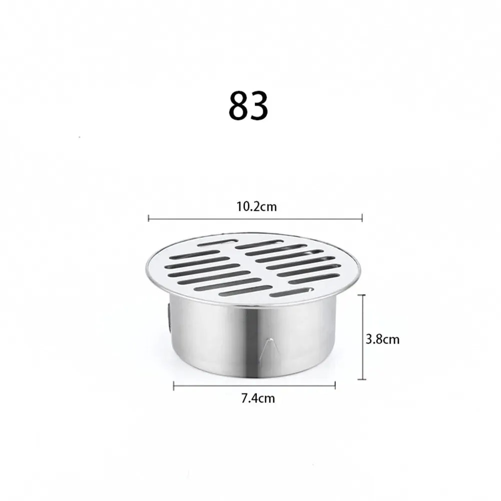 Stainless steel round floor drain with slotted top, 10.2 cm diameter, 3.8 cm height.