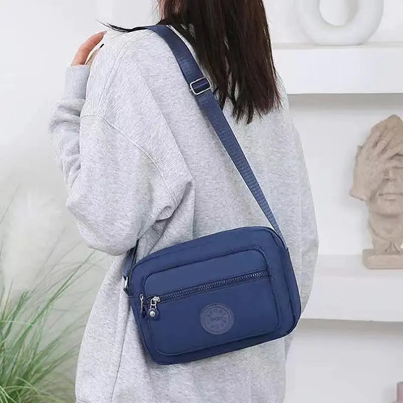 Simples Market navy blue crossbody bag with front zip pocket and adjustable strap