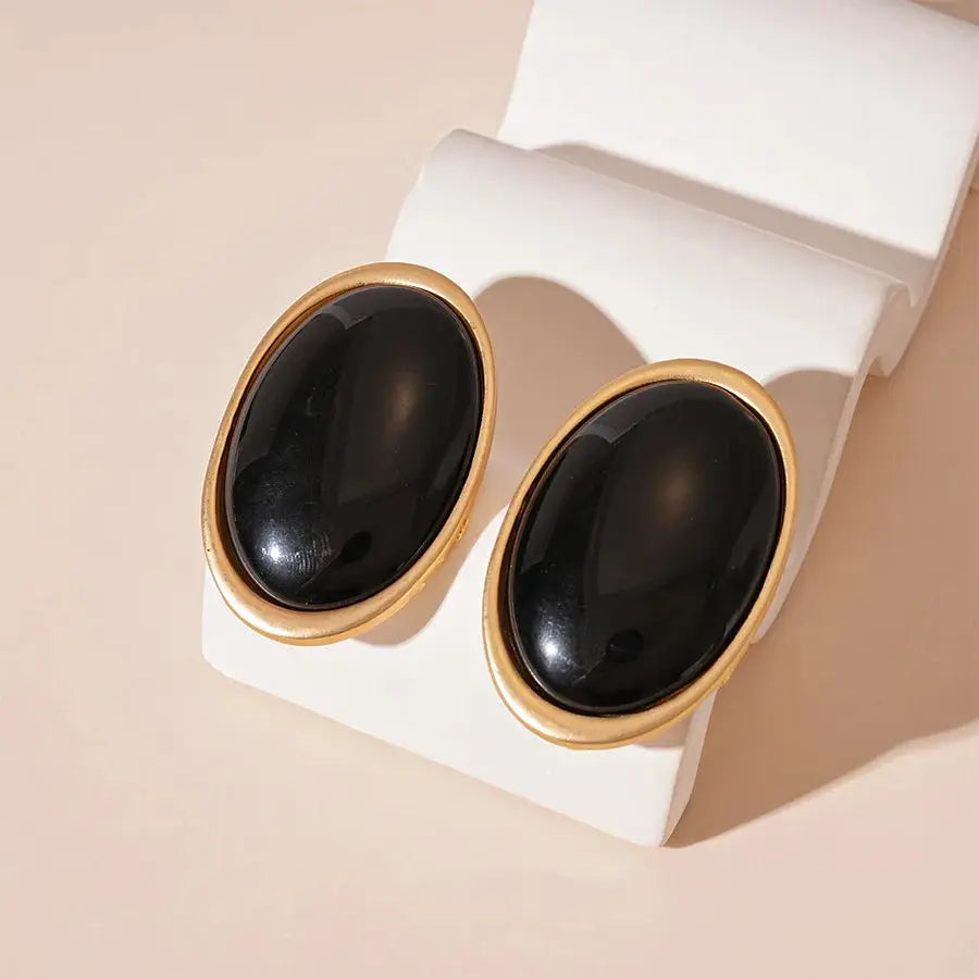 Vintage black resin oval stud earrings with gold-tone bezel, pair