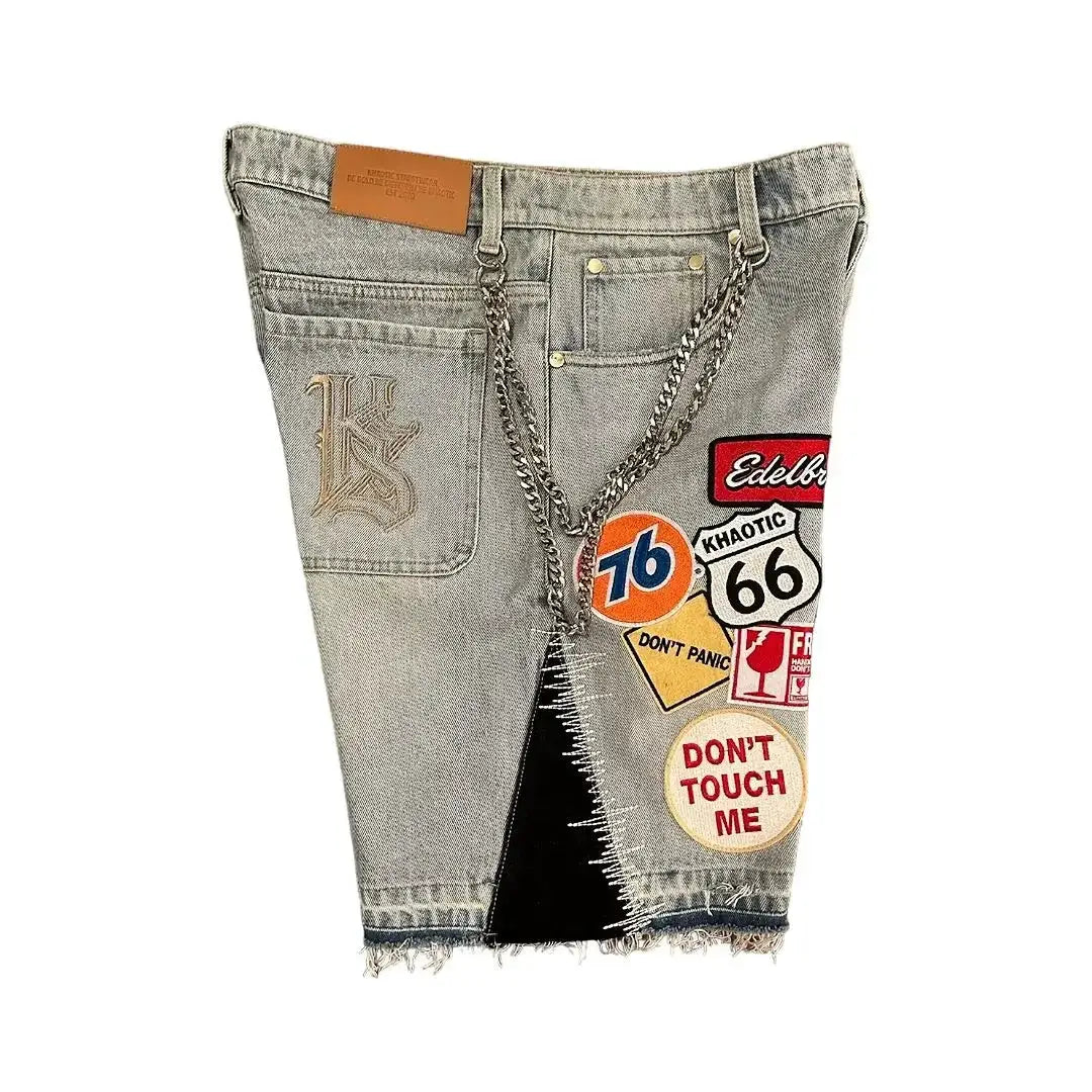 Patchwork denim shorts with chain belt, light blue wash and colorful graphic patches.