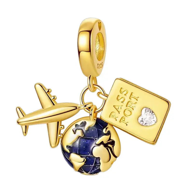 Gold-tone 4-piece charm set featuring airplane, globe, and square tag with heart gem for bracelets